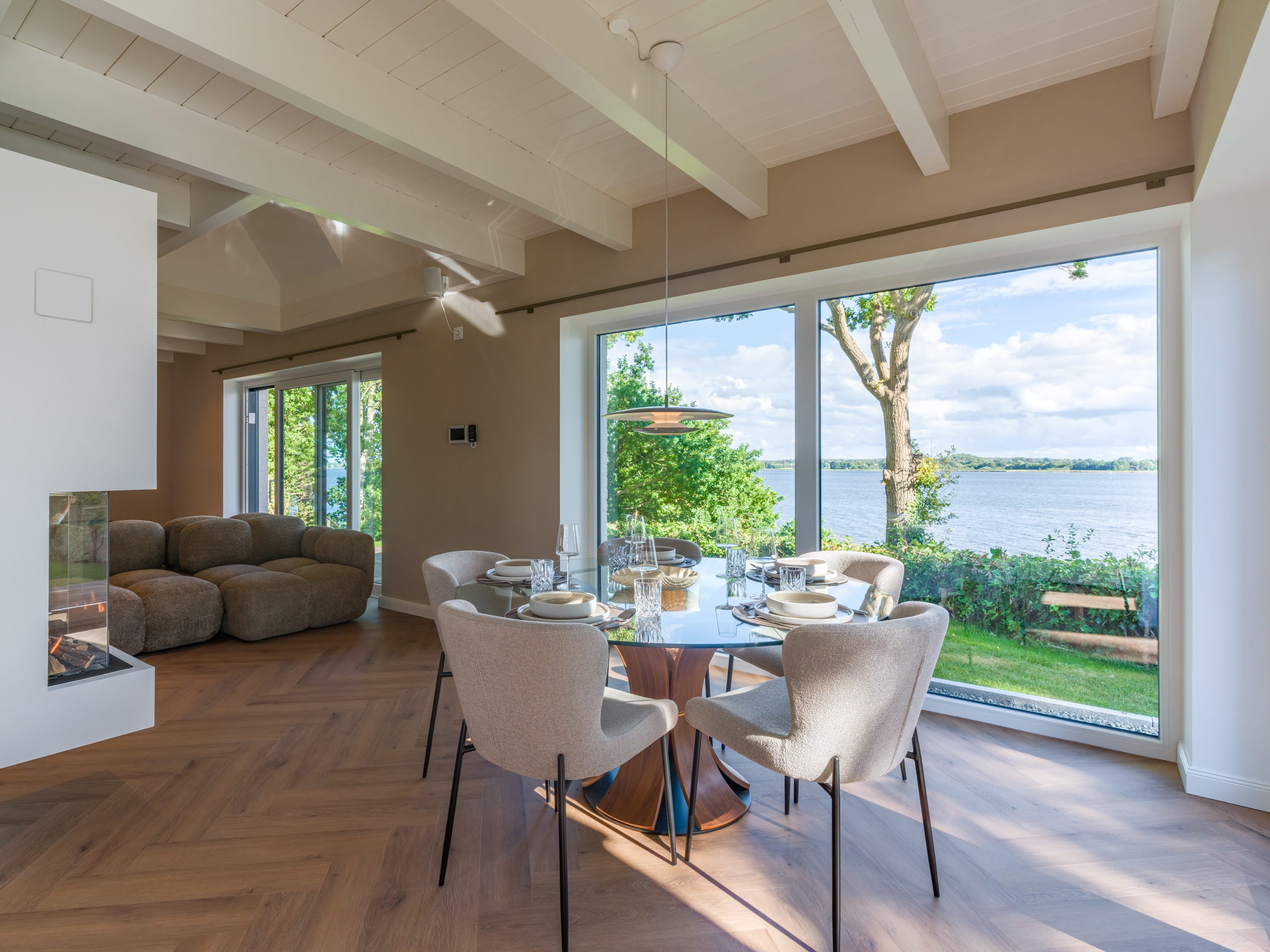 Offener Wohn- und Essbereich mit Panoramafenstern zur Schlei