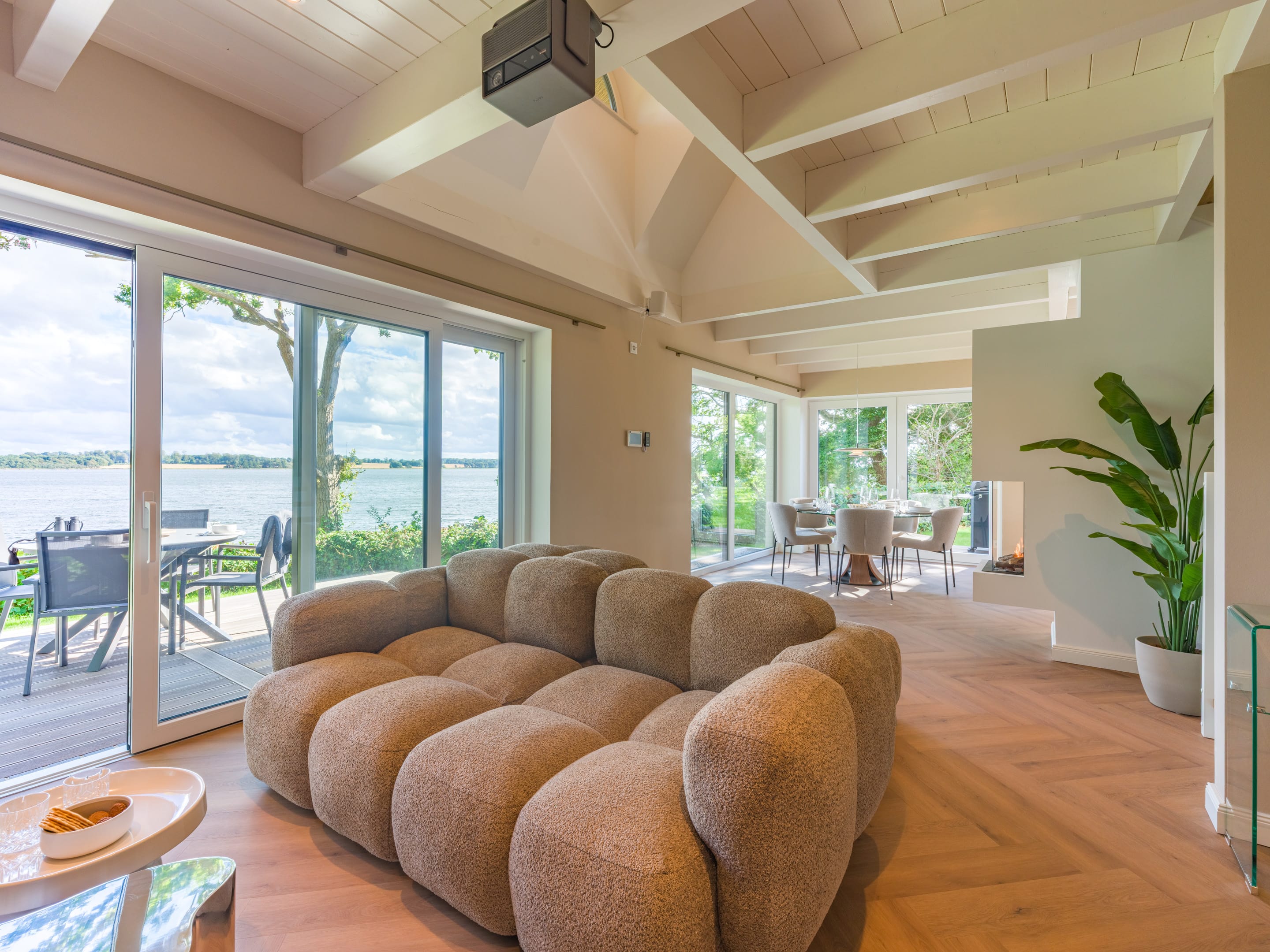 Wohnzimmer mit Fischgrätboden und Schiebetür zur großen Terrasse