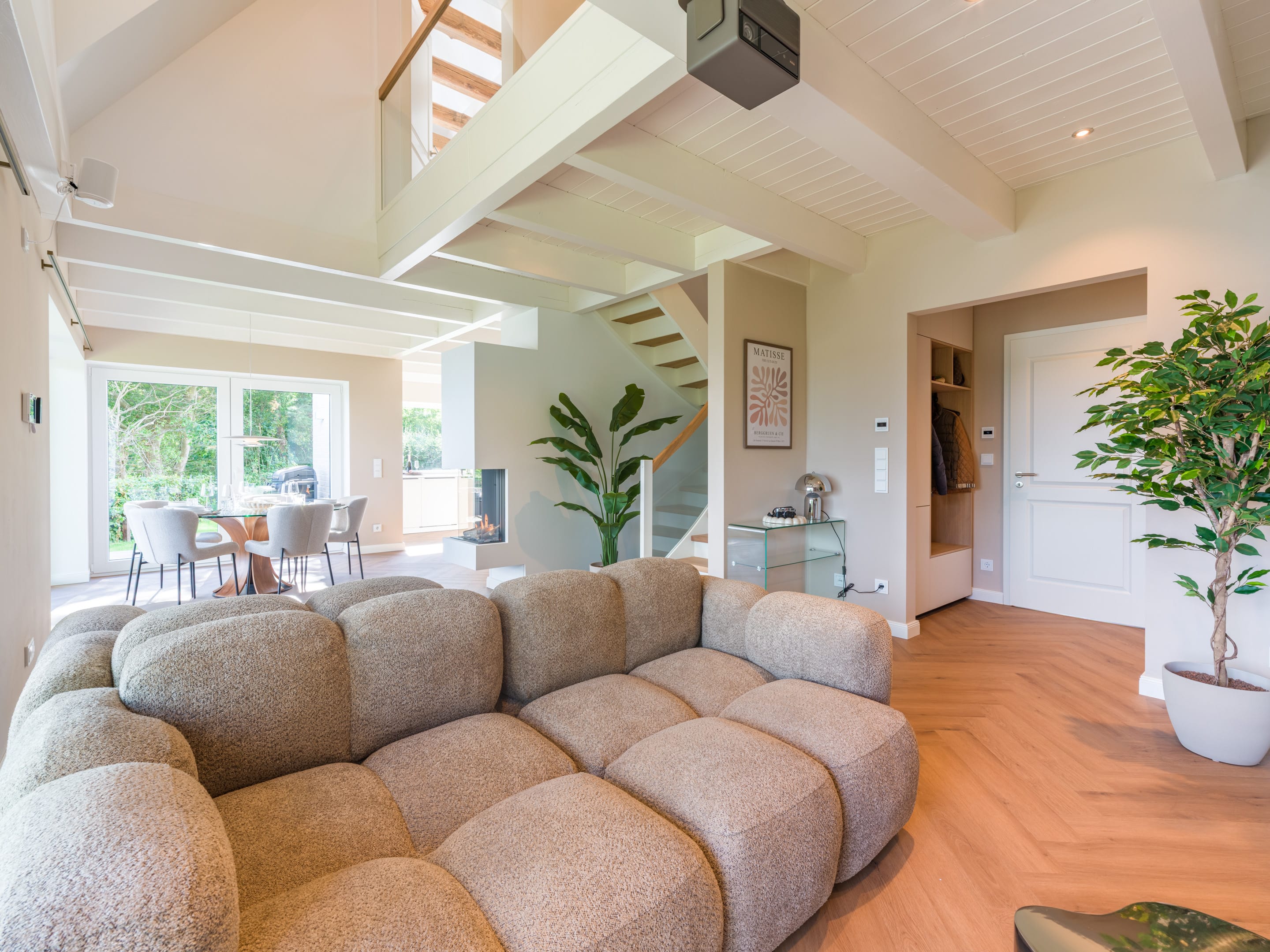 Wohnzimmer mit Sofalandschaft, Galerie und offener Holzbalkendecke