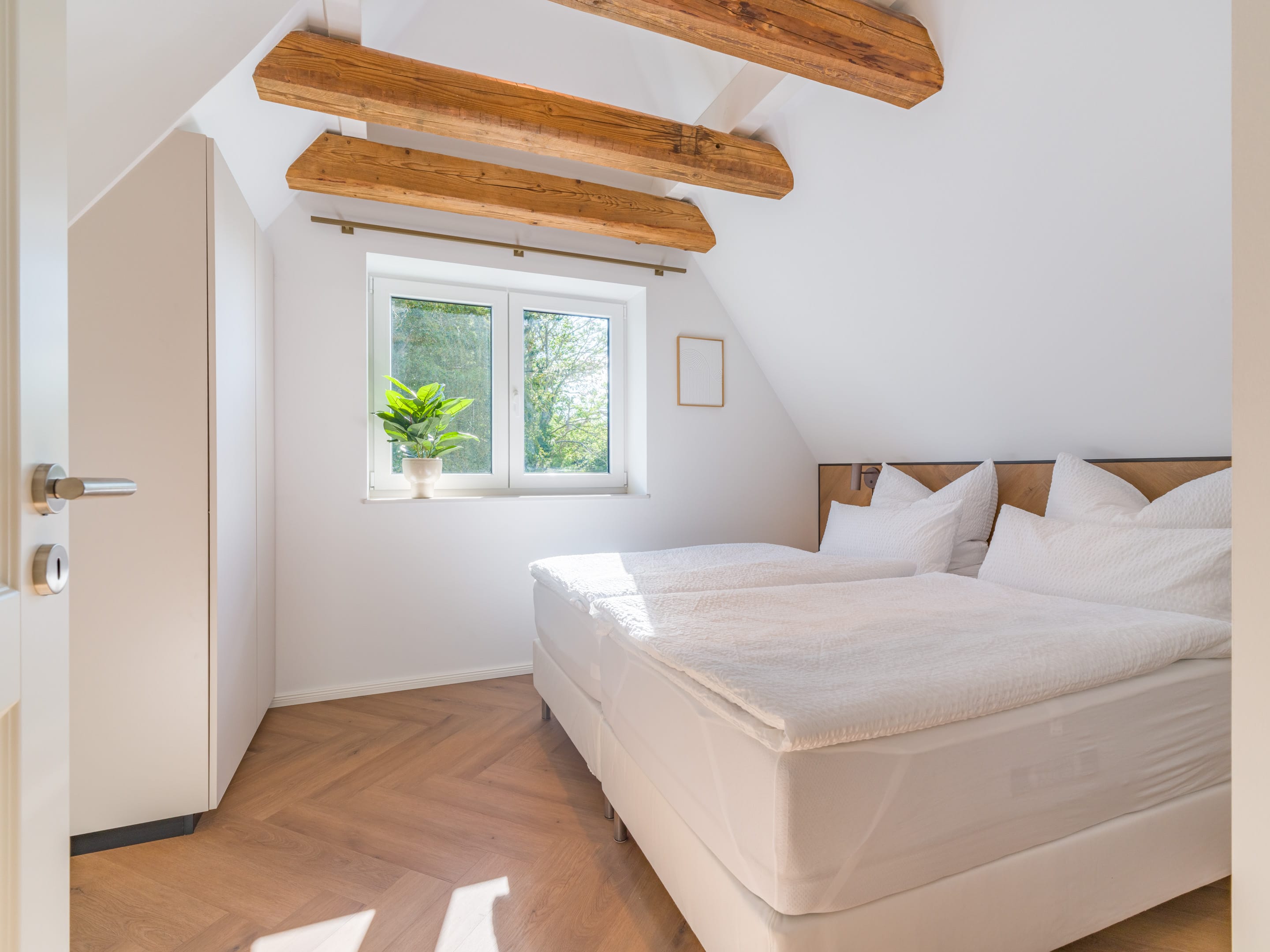 Zweites Schlafzimmer mit Doppelbett unter der Reetdachschräge